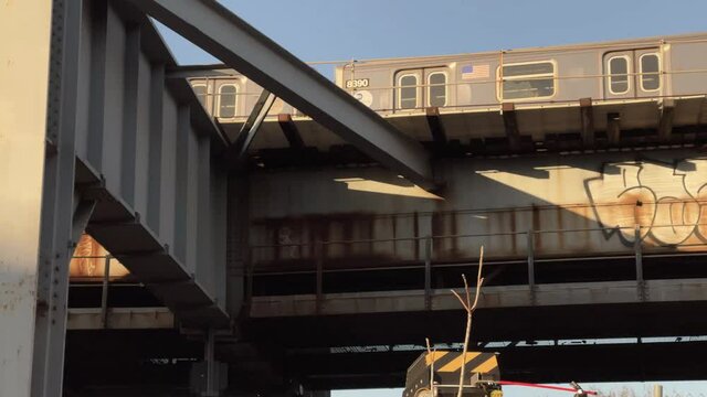 driving past graffiti pieces and subway train on Williamsburg Bridge Manhattan to Brooklyn New York City NYC