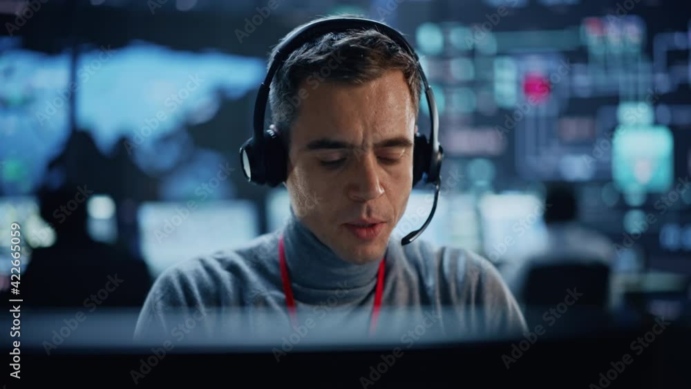 Aufkleber Portrait of Professional IT Technical Support Specialist Working on Computer in Monitoring Control Room with Digital Screens. Employee Wears Headphones with Mic and Talking on a Call.