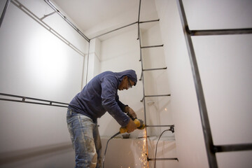 Colombian metal carpenter polishing metal in a dressing room