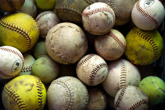 baseballs and softballs in a pile 