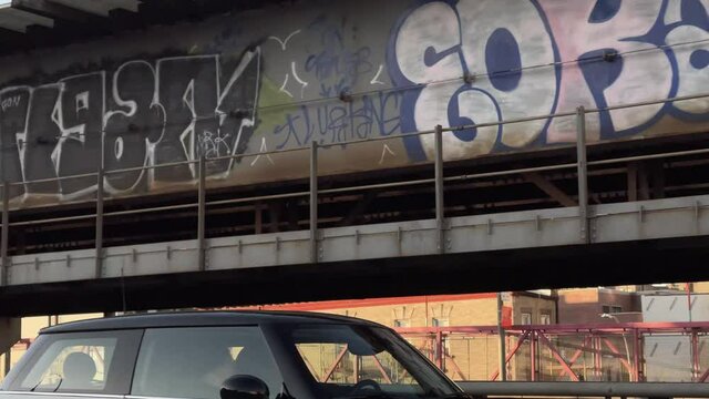 driving past graffiti pieces spray paint tags on Williamsburg Bridge in New York City NYC