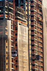 Residential building construction site with net protection and outdoor elevator in Sao Paulo city