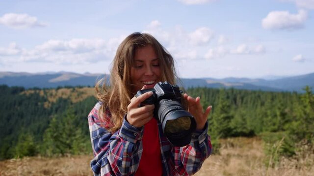 Woman taking photos on camera in mountains. Photographer shooting landscape