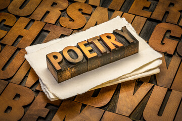 poetry word abstract - text in vintage  letterpress wood type against handmade paper and alphabet