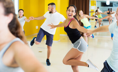 Fototapeta na wymiar Smiling people practicing vigorous lindy hop movements in dance class