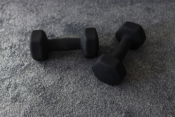 fitness and exercising at home, couple of black dumbbells on carpet indoor