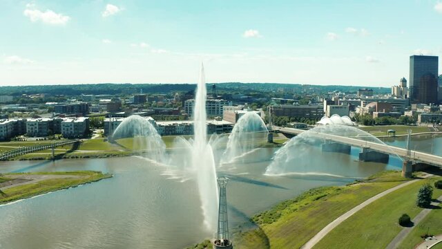 Drone circling river fountain revealing downtown Dayton skyline