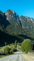 Carretera con montes y gran vegetaci&oacute;n de fondo.