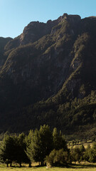 Gran monte con &aacute;rboles a sus pies y cielo despejado.