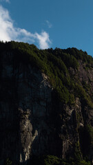 Cima de un gran monte lleno de vegetaci&oacute;n y un cielo despejado con pocas nubes.