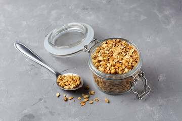 Glass jar with granola on the table.