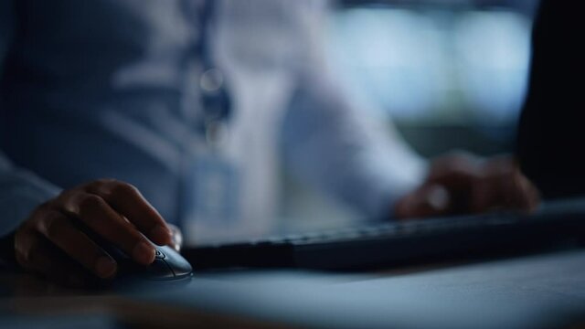 Close Up of a Professional Office Specialist Working on Desktop Computer in Modern Technological Monitoring Control Room with Digital Screens. Manager Typing on keyboard and Using Mouse.