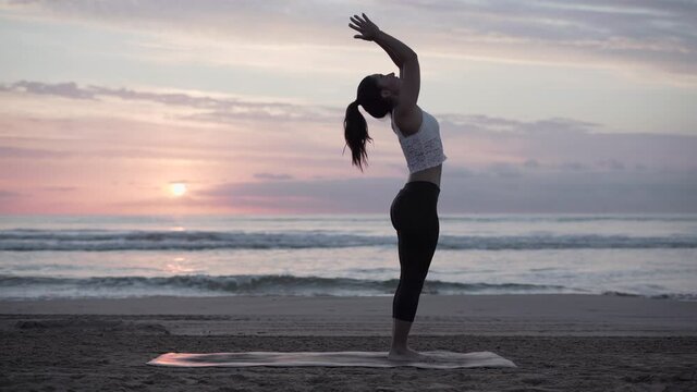 Slim Woman Exercising And Practicing Mountain Pose,Tadasana On Beach At Dawn. - wide shot