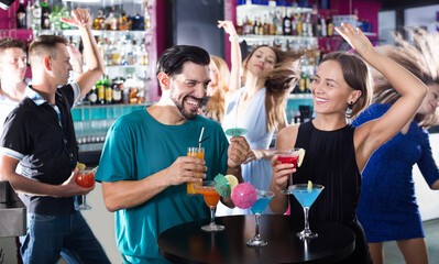 Young students dancing on party with cocktails at the club