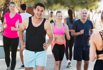 People leading healthy lifestyle, jogging during outdoor workout on city seafront