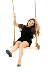 Joyful girl swinging on rope swing. Photo session in the studio