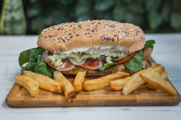 Vegan seitan sandwich with vegetables and coriander-based mayonnaise. Light background, copy space. Vegan food concept.
