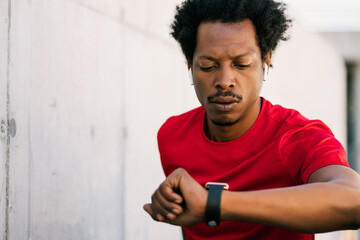 Fitness man checking time on smart watch.