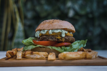 Vegan lentils burger with cheddar and parsley-based sauce. Light background, copy space. Vegan food concept.