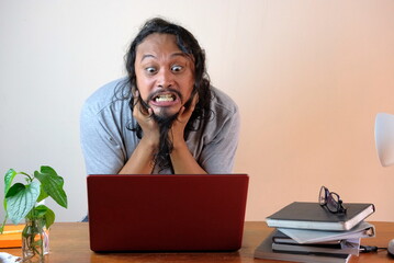 rage asian man in front laptop, stressed casual guy while working at home, funny frustrated...