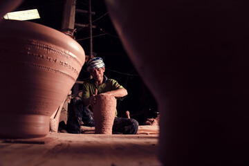 A professional Thai old man uses artisanal pottery from Thailand, Asia.
