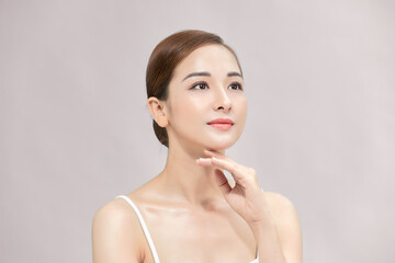 Female beauty concept. Cheerful girl with nude makeup and perfect skin smiling standing over white background.