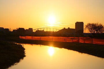 After the rain, the sunrise and sky were reflected in the puddle.