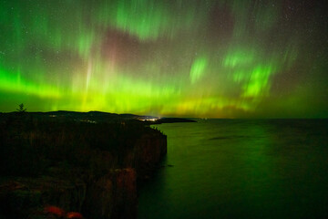 Northern Lights or Aurora Borealis in the Night Sky, Amazing Starry Night Background and Reflection on Lake Superior Minnesota Cliff on the North Shore