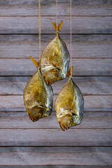 Three smoked sea fish Selene close-up on a string