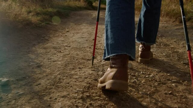 Man in hiking boots walking on mountain road. Male hiker trekking in mountains