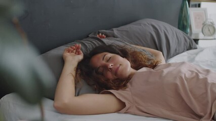Young beautiful woman falling down on her back on bed with eyes closed and sleeping - Powered by Adobe