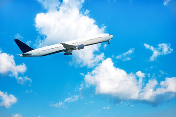 Fototapeta na wymiar A big white jet flying on background of blue cloudy sky.