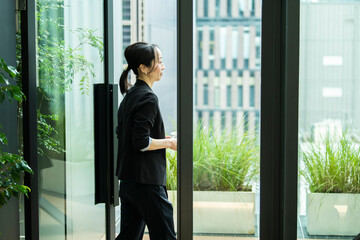 オフィスのテラスに出る会社員の女性