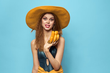 Woman in swimsuit hat exotic fruits summer fun blue background