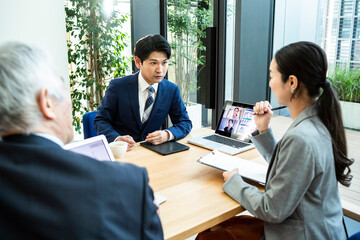 都心の企業で働くビジネスチームのオンライン会議風景