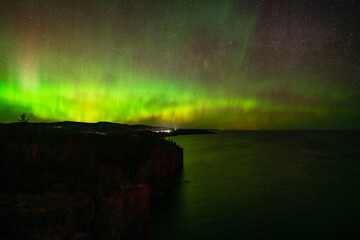 Northern Lights or Aurora Borealis in the Night Sky, Amazing Starry Night Background and Reflection on Lake Superior Minnesota Cliff on the North Shore