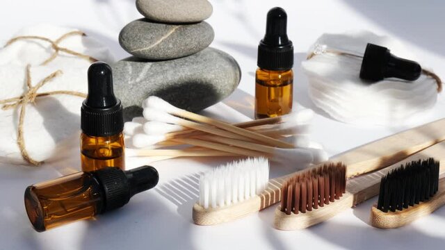 Reusable and recycable bathroom accessories on white background. Trendy shadows. Zero waste concept. Natural cosmetics and eco living concept. Essential oil or serum