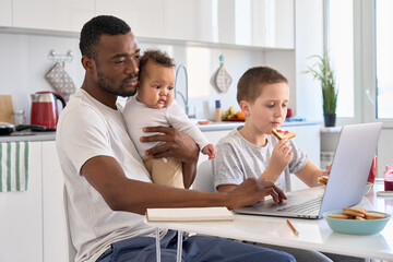 Young Black father, African dad remote working or distance learning online from home office using...