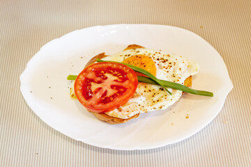 Roasted egg sandwich with tomato, pepper and green onions on toast