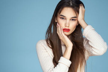 Brunette in a white sweater red lips charm long hair blue background