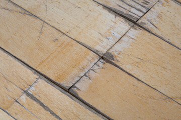 old parquet or laminate flooring deformed by water exposure. scratched floor covering close-up