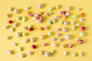 colorful sweet candies on yellow background, top view