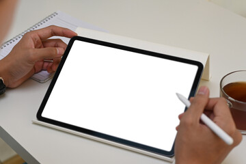 Close up vie of man holding digital tablet with blank screen and stylus pen.