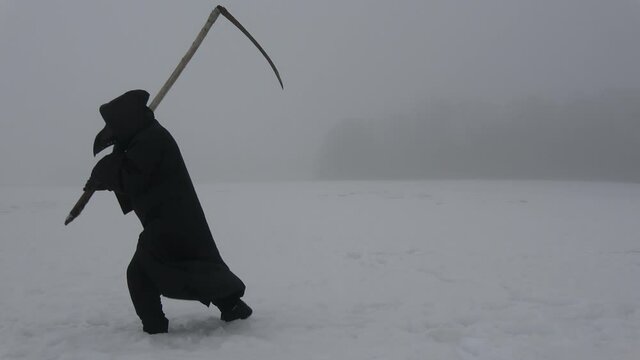 Plaque doctor in black bird beak mask with scythe goes through a snowy field in mist.   Image of all pandemics