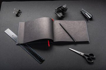 Black office on a black table. Black notebook and stationery. Black office supplies.