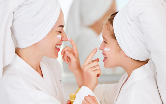 Laughing mother and daughter doing beauty routine