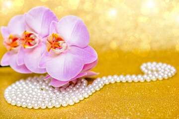 Naklejka na ściany i meble purple Orchid and pearl necklace on a shiny gold background 