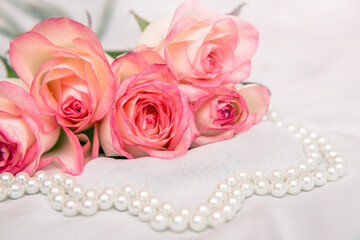 The branch of pink rose on white fabric background
