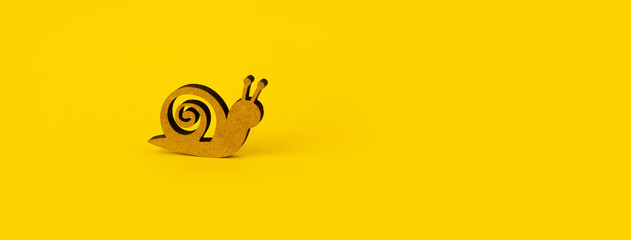 wooden snail over yellow background, panoramic mock-up with space for text © alesmunt