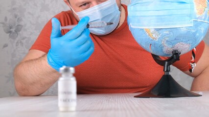 vial with a vaccine against the coronavirus, in the background a man is vaccinating the planet, the globe. Corona virus treatment concept, injection during a pandemic. Travel concept during a pandemic